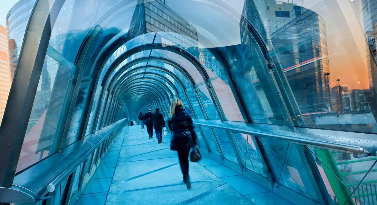 Menschen gehen auf einer Brücke zwischen moderner Architektur 