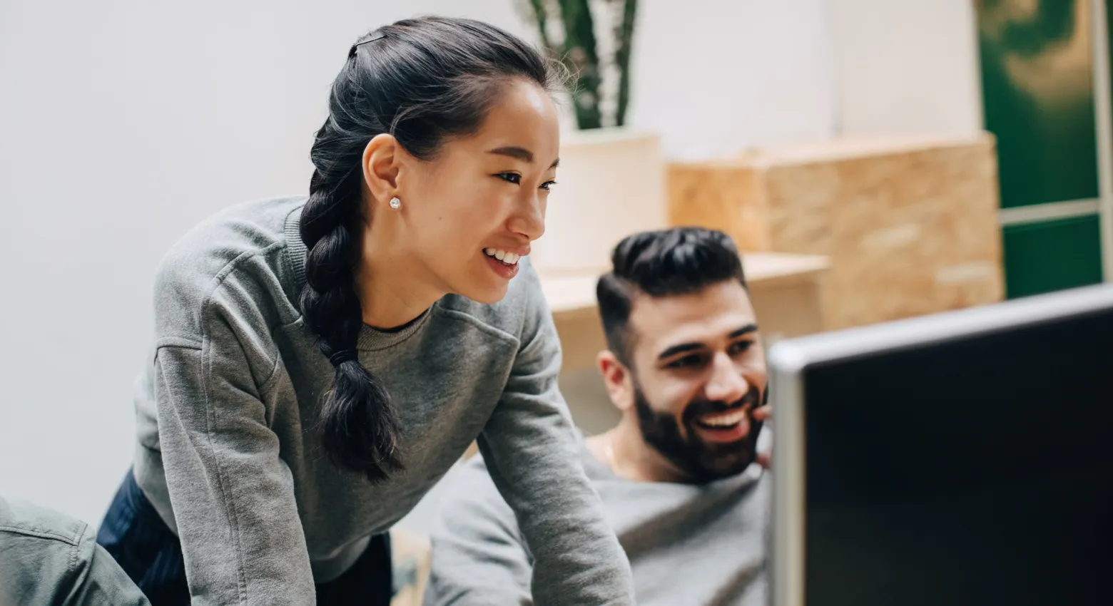 Eine Frau und ein Mann, die gemeinsam an einem Computer arbeiten 