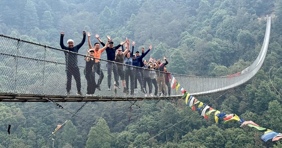 Mitarbeitende auf einer Brücke in Nepal